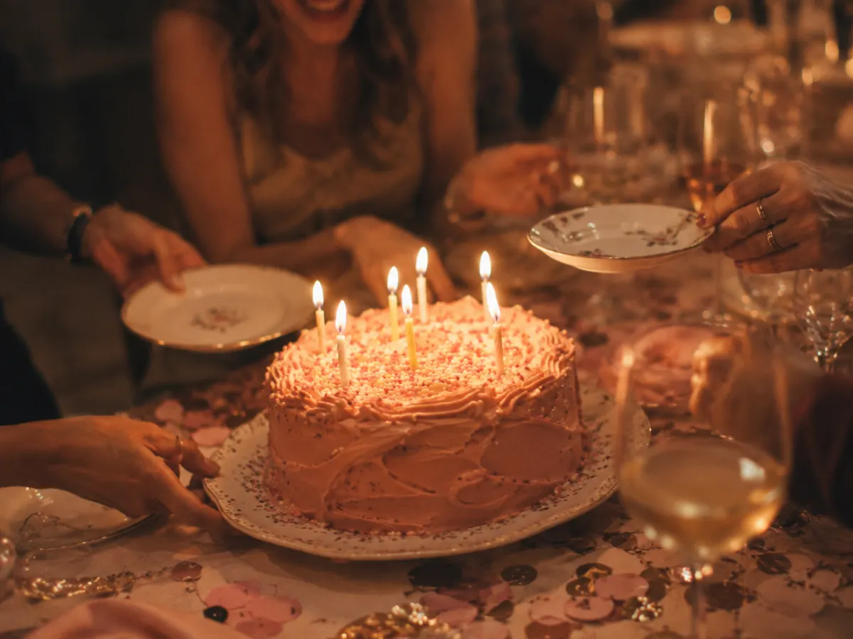 Geburtstagsgäste lachen am gedeckten Tisch
